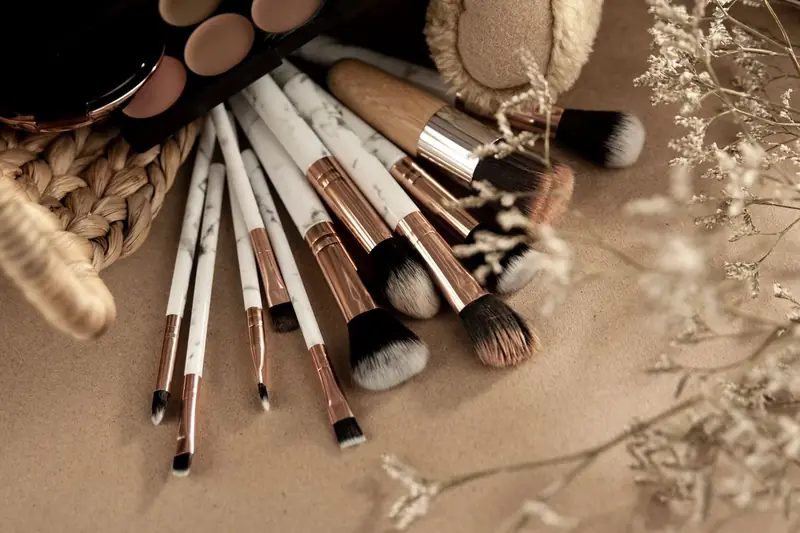 Make-up-Pinsel und Lidschatten auf hellem Untergrund