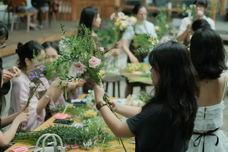 Frauen binden gemeinsam Blumen bei einem Workshop