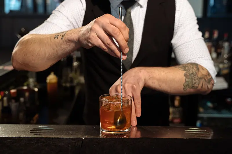 Barkeeper mixt einen Cocktail mit Eis