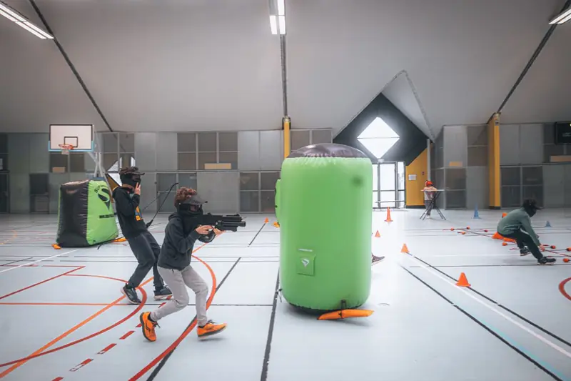 Lasertag-Spiel in einer Halle mit aufblasbaren Hindernissen