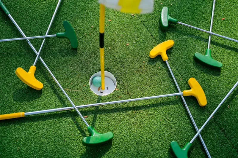 Bunte Minigolf-Schläger rund um ein Loch
