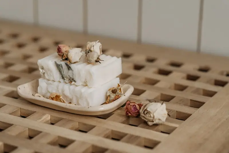Handgemachte Seifen mit getrockneten Rosen auf einer Schale