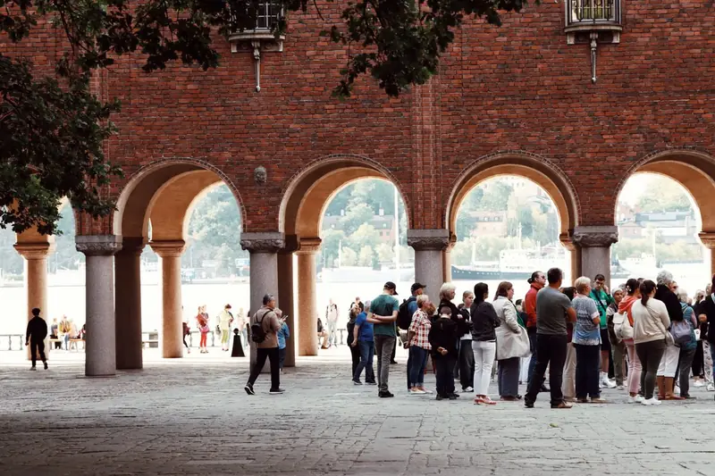 Gruppe bei einer Stadtführung unter historischen Bögen