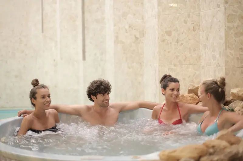 Vier Freunde entspannen gemeinsam in einem Whirlpool