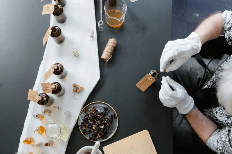 Arbeitstisch mit Glasflaschen und Zutaten zum Parfum mischen