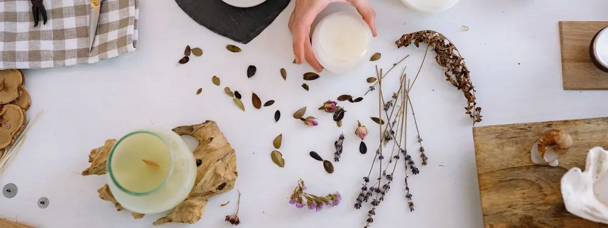 Tisch mit Material zum Kerzengießen und Trockenblumen